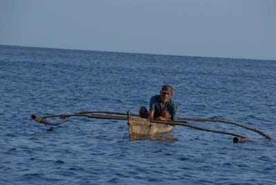人力でダガーボートを漕ぎ漁をする漁師